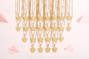 Collezione di 26 ciondoli con lettere dorate disposti su uno sfondo di cuori rosa delicati