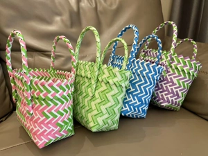 Detail of four colorful handmade woven tote bags on a sofa showing various color patterns