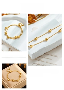 Detail of double-layer golden chain bracelet with heart pendants in a gift box