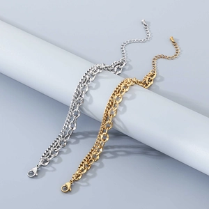 Detail of layered gold and silver cuban link bracelets with adjustable lobster clasp closure