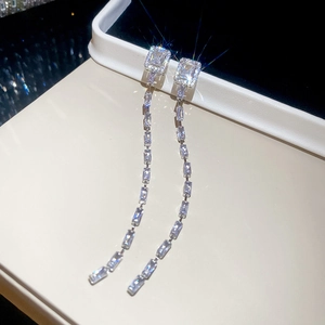 Close-up of sparkling square zircon tassel earrings with long chain fringe detail