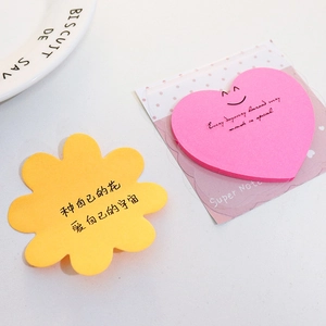 Detail of flower and heart shaped sticky notes with motivational quotes on a desk