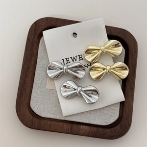 Close-up of gold and silver metallic bow hair clips on jewelry display card
