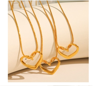 Détail de trois colliers en acier inoxydable doré à l'or 18 carats avec pendentifs cœur