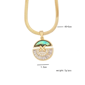 Close-up of golden necklace with green abalone shell and cubic zirconia pendant details