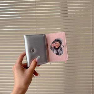 Detailed view of silver ballet-style tri-fold wallet with pink lining and heart window