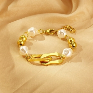 Detail view of gold bead and baroque pearl bracelet with interlocking rings and clasp