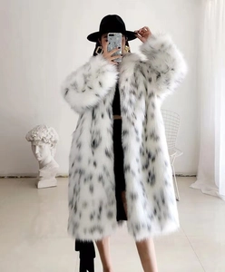 Détail d'un manteau long en fausse fourrure avec imprimé léopard des neiges et texture peluche