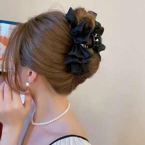 Detailed view of an elegant black mesh layered bow hair claw clip for thick hair styling