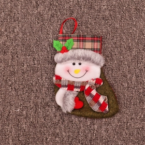 Détail de la chaussette de Noël verte avec bonhomme de neige et bonnet à carreaux