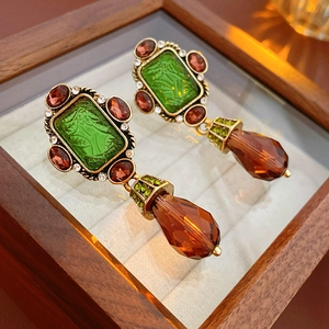 Detail of vintage earring with green square stone and crystal rhinestones in wood box