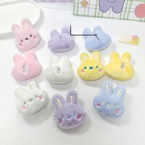 Colorful plush bunny head accessories with embroidered faces and back slit design