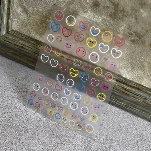 Colorful smiley face nail stickers with heart and round shapes on transparent backing