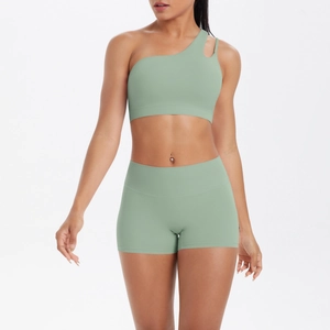 Close-up of sage green one-shoulder sports bra and high-waisted yoga shorts set