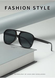 Detail view of retro double-bridge pilot sunglasses with black oversized frames on books