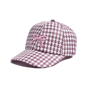 Detail of pink houndstooth plaid fabric and 3D bow embroidery on the baseball cap