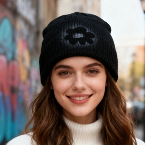 Street style black knit beanie with hand-painted floral design on a graffiti backdrop