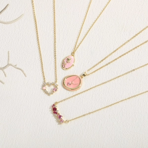 Bohemian style pink heart and rose pendants with 14K gold plating on textured background