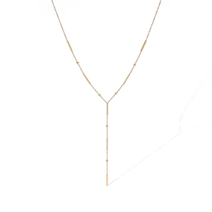 Detail of elegant gold-plated Y-shaped necklace with bar and bead charm chain elements