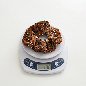 Brown velvet scrunchie with shiny gold sequins shown on a digital scale weighing 18g
