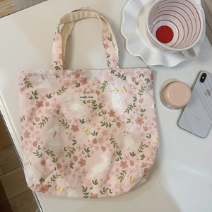 Detail der rosa Canvas-Tasche mit süßen Kaninchen- und Blumenmotiven und Tragegriffen