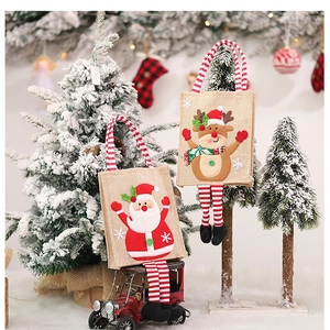 Dettaglio di sacchetti regalo in juta natalizi con Babbo Natale 3D e gambe penzolanti