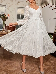 Détail d'une robe élégante en dentelle blanche avec col en V et texture fleurie