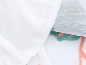 Détail de couture de qualité et imprimé végétal sur tissu mousseline blanc léger