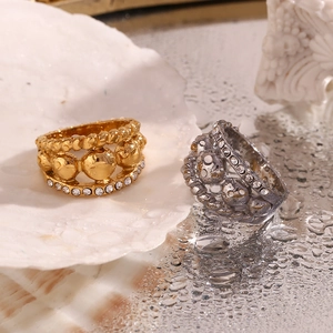 Detail of 18K gold and silver layered rings with crystals on shell and water droplets