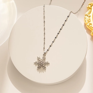 Vue macro d'un pendentif flocon de neige argenté serti de cristaux blancs brillants