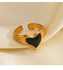 Detail of vintage 18K gold plated heart ring with black enamel on silk fabric