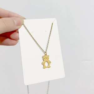 Gros plan du collier avec pendentif ours doré sur carte avec détail évidé circulaire