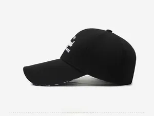 Detail of white artistic embroidery on side of black cotton outdoor baseball cap