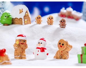 Miniature resin Christmas figurines including gingerbread man and snowman on faux snow