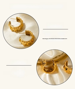 Close-up of gold 18k plated stainless steel C-shaped stud earrings with rivet texture