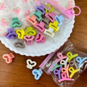 Assorted candy-colored mini flower hair clips for girls in a cute pastel gift bag set