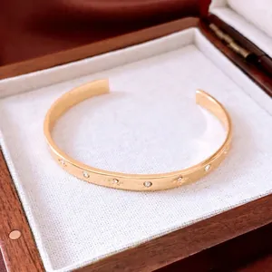 18K gold plated wrinkled open cuff bracelet featuring a minimalist star-etched zircon design