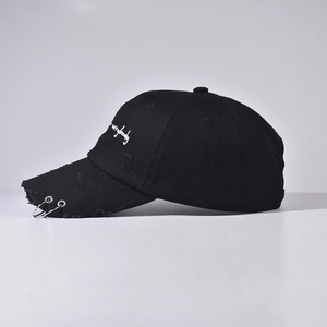 Distressed black denim baseball cap featuring metal rings and embroidered lettering