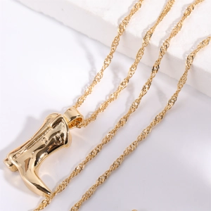 Gold plated cowboy boot pendant necklace with a minimalist abstract twisted rope chain design