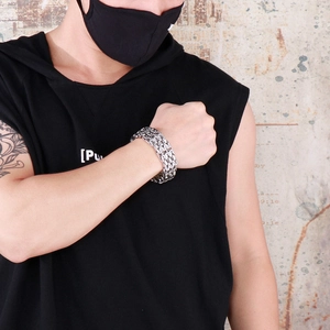 Detail of men's wide stainless steel chain bracelet with multi-row weave design
