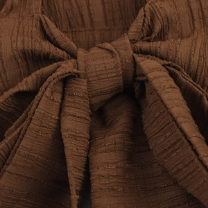 Close-up of deep brown beach set fabric featuring a stylish twist knot tie design