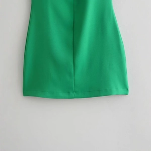 Gros plan sur la robe sans manches vert émeraude avec texture de tissu et détails d'ourlet