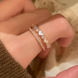 Close-up of double-layer rose gold ring with heart-shaped mother of pearl and zircons