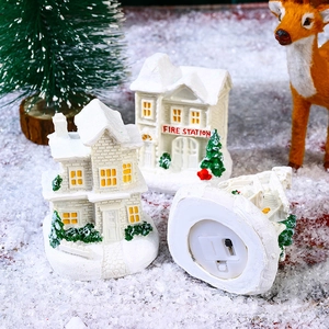 Detailed base view of glowing resin Christmas house showing battery compartment and LED switch