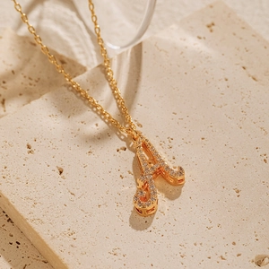Macro shot of 18K gold plated letter A pendant necklace with sparkling zircon inlay
