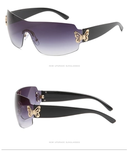 Detail of oversized shield sunglasses with purple gradient lens and gold butterfly hinge