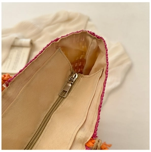 Detail view of the colorful straw tote featuring a beige fabric lining and zipper pocket
