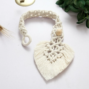 Detail of a handmade macrame heart-shaped curtain tieback with cotton rope and wood bead
