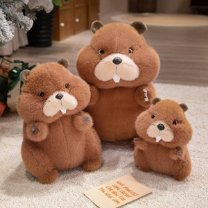 Three plush groundhog dolls in different sizes on white carpet with cozy background