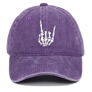 Close-up of white skeleton hand embroidery on washed purple cotton baseball cap